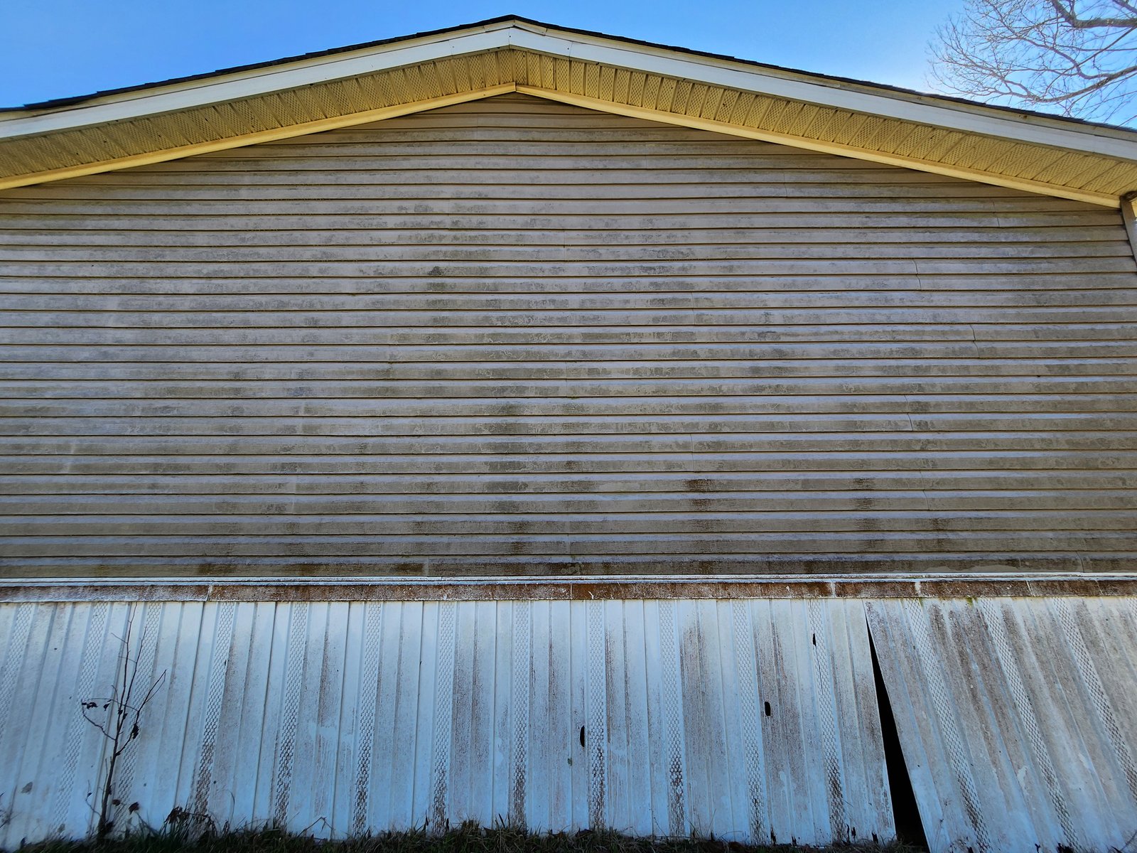 Vinyl siding gable end with heavy algae and mildew