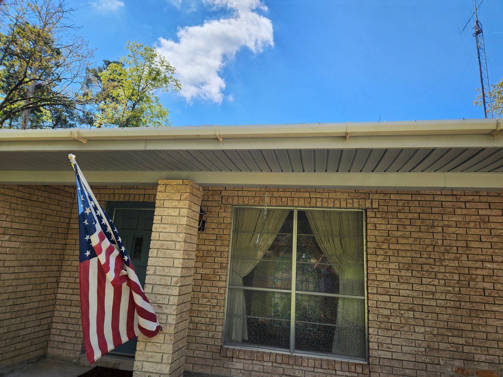 Same brick home after professional soft washing — brick restored to original color