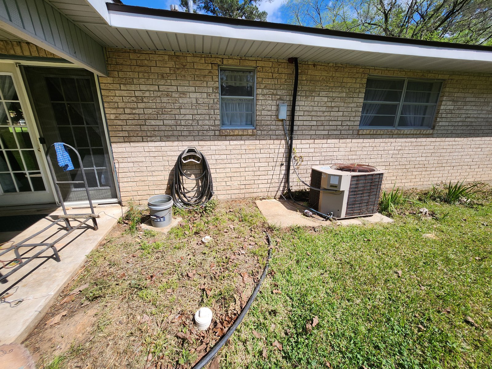 Side of brick home after soft wash, algae gone