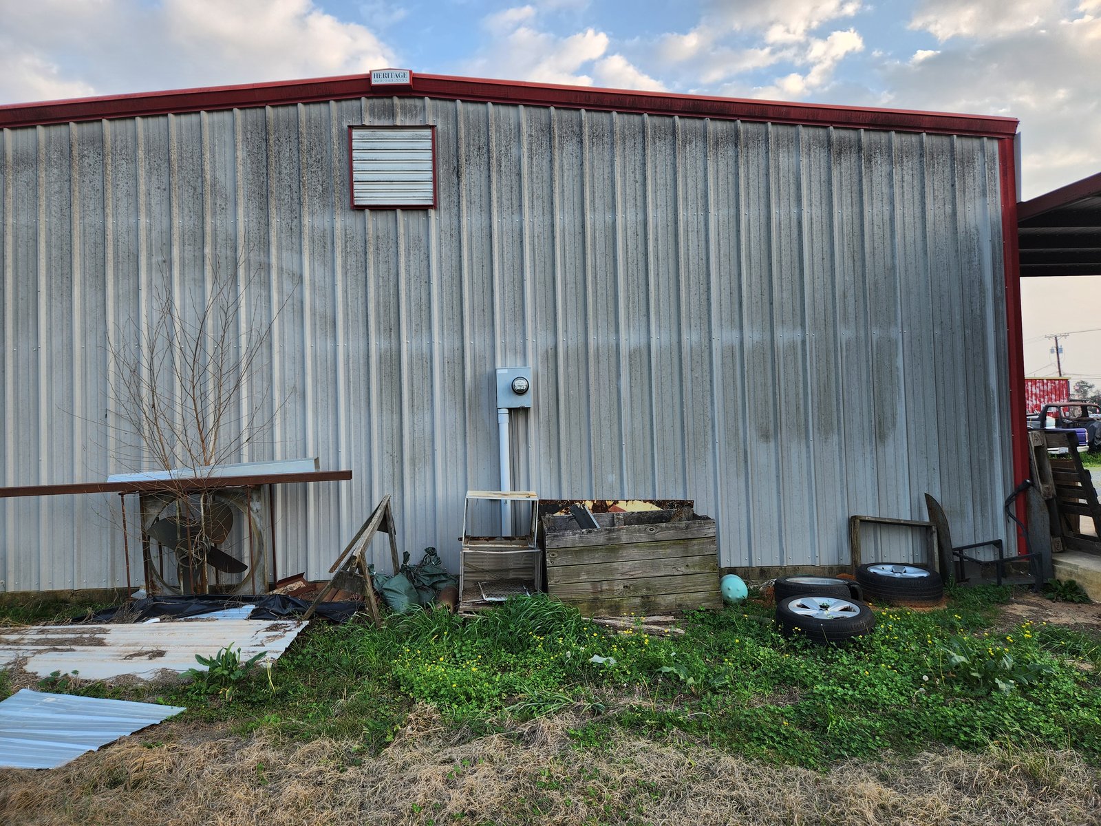 Large commercial metal barn with oxidation and algae