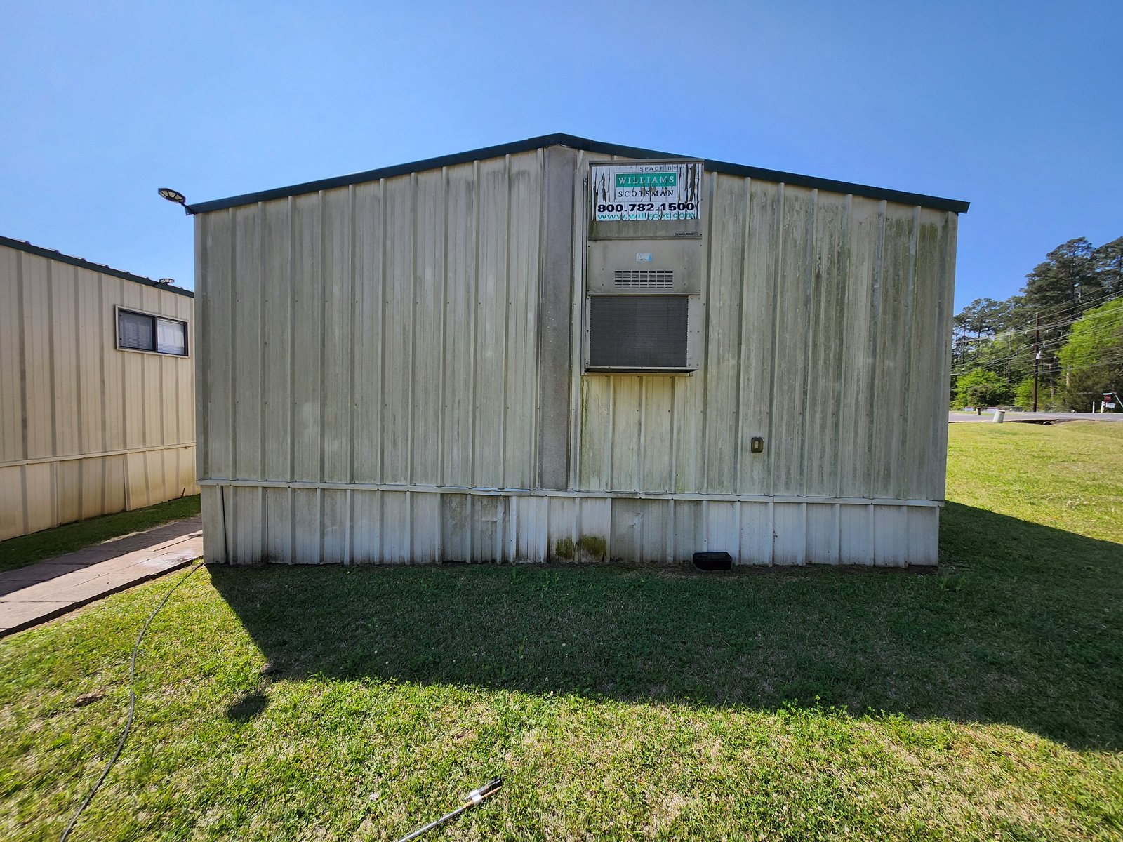 Portable commercial building with mold and algae streaks